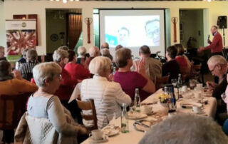 Publikum im Saal vor einer Leinwand